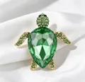 Detail of a luxury sea turtle brooch featuring a large faceted green crystal shell - Light Green