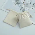 Détail de pochettes en coton crème à cordon pour bijoux sur un fond floral élégant - Style Corde de Coton à Bouche Plate / 7x9cm