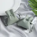 Vista detallada de bolsas de microfibra verde salvia con cordón para guardar joyas. - Estilo de Cordón con Volantes / 7*8cm