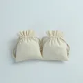 Detail showing two small cream cotton drawstring pouches for jewelry storage - Ruffle Edge Style / 7x9cm / Beige
