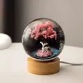 Nahaufnahme eines Kristallkugel-Nachtlichts mit Kirschblütenbaum und weißem Reh - Hirsch unter dem Baum (8cm) / 8cm