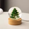 Detail of crystal ball night light featuring a Christmas tree and white deer inside. - Christmas Elk (Plug-in)