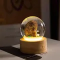 Vue macro d'une lampe boule de cristal avec pierre gravée et figurine de cerf - Amour pour Toujours / Rechargeable