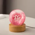 Elegant pink resin crystal ball night light with reindeer figurines on circular wood base - Red Elk (Plug-in)