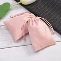Primer plano de bolsas de gamuza rosa para joyas con cordón sobre madera. - 5*7cm / Rosa