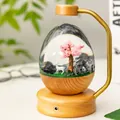 Eiförmiges Mikrolandschaft Nachtlicht mit Hirsch und Kirschblüte auf einem warmen Holzsockel - Steckerversion / Buchenholzfarbe