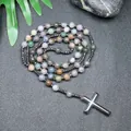 Detalle de cuentas de ágata india natural y colgante de cruz de hematita en fondo oscuro. - Ágata de la India