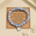 Macro detail of blue natural stone beaded bracelet with silver apple charm on gift card - Aquamarine