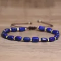 Detailopname van blauwe natuursteen kralen en gouden spacers op een gevlochten armband - Lapis Lazuli