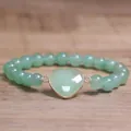 Macro-weergave van een groene hartsteen op een 8 mm natuurstenen kralenarmband. - Groene Aventurijn