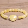 Detailweergave van een lichtgele natuurstenen kralenarmband met hartvormige hanger - Gele Aventurijn