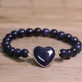 Detailed view of 8mm blue goldstone beaded bracelet with sparkling heart charm. - Blue Sandstone