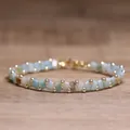 Handmade woven Tila bead bracelet with gold accents in pale blue, mint and white - Amazon