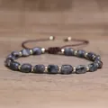 Handmade natural stone bracelet with grey marbled beads and gold spacers on wood base - Black Flash