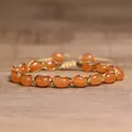 Detailed view of handmade woven bracelet with orange oval natural stone beads - Red Aventurine