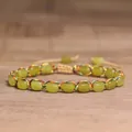 Close-up of the intricate colorful woven thread and smooth green stone beads - Olive Jade