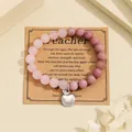 Detailed shot of natural pink stone bracelet with apple charm on teacher gift card - Pink Quartz Rhodonite