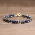 Handmade blue Tila bead and gold round bead woven bracelet for women on wooden surface - Lapis Lazuli