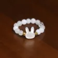Macro detail view of white shell rabbit charm and natural stone beaded elastic ring - Rabbit / Silver White