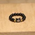 Close-up detail of a handmade elastic ring featuring a cute cat shaped shell bead - Cat / All Black