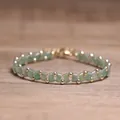 Elegant handmade woven bracelet featuring green Tila beads and gold beads on a wooden surface - Green Aventurine