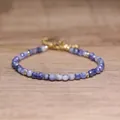 Macro detail of faceted blue natural stone beads and gold spacers on a delicate bracelet - Blue Spot Jasper