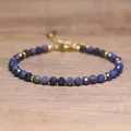 Detail view of a handmade blue faceted natural stone beaded bracelet with gold spacers. - Spotted Lapis Lazuli