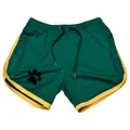 Detail of green mesh athletic shorts featuring yellow trim and paw print logo - M / Bottoms / Green with Yellow Trim
