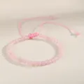 Macro view of a 4mm pink natural stone bead bracelet with adjustable woven cord - Rose Quartz