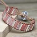 Detail showing pink cylindrical beads and silver bars woven into a brown leather bracelet - Watermelon red