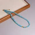 Handgemaakte ketting met blauwe natuursteen kralen, gouden details en verstelbare sluiting - Zwarte Lijn Turkoois