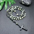 Collar de rosario de piedra natural con cuentas verdes y cruz negra sobre fondo oscuro. - Piedra Verde Natural