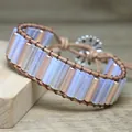 Macro view of handmade woven bracelet featuring iridescent opal beads and a floral button clasp - Opal