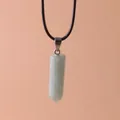 Macro view of a hexagonal light green quartz crystal pendant on a black cord necklace - Green Aventurine
