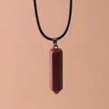 Close-up of hexagonal brown goldstone pillar pendant necklace with black cord - Goldstone