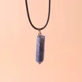 Close-up van een zeshoekige blauwe lapis lazuli kristallen hanger met zwart koord. - Lapis lazuli
