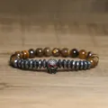 Detailed view of gothic skull charm bracelet with faceted hematite and tiger eye stone beads - Yellow Tiger