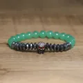 Detailed view of a gothic skull charm bracelet featuring green stone beads and hematite. - Light Green