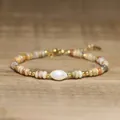 Macro detail of handmade natural stone beaded bracelet featuring a central baroque pearl - Pale Yellow