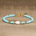 Detailed view of baroque pearl and turquoise beaded bracelet on a wood surface. - Light Blue