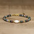 Macro detail of exquisite handmade bracelet with natural stones and central baroque pearl - Dark Green