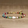 Macro detail of a colorful beaded bracelet featuring a unique Baroque pearl center - Colorful