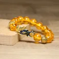 Détail macro du bracelet Pixiu ambre avec perles gravées du mantra six mots - Perles Mantra Jaune Ambre Translucides (10)