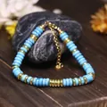 Macrodetail van een handgemaakte verstelbare turkoois kralenarmband met gouden accenten. - Zwarte Lijn Turkoois