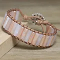 Close-up view of pink natural stone tube beads on a woven leather wrap bracelet - Pink Aventurine