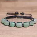 Primo piano dettagliato di perline in pietra naturale verde su un bracciale chakra nero regolabile - Verde