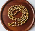 Détail de 108 perles de mala en jaspe avec pendentif lotus doré sur un plateau en bois. - Style Collier Mala Bracelet Enroulé (BXMY001) / Couleur Jaspe Paysage
