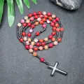 Vista detallada de un collar artesanal de ágata roja rayada con una gran cruz de hematita - Ágata roja a rayas