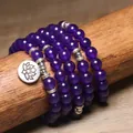 Primo piano del bracciale con 108 perle di ametista viola da 8 mm e ciondolo loto - Purple Crystal