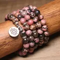 Dettaglio di un bracciale di perle di rodonite da 8mm con ciondolo a fiore di loto - Rodocrosite